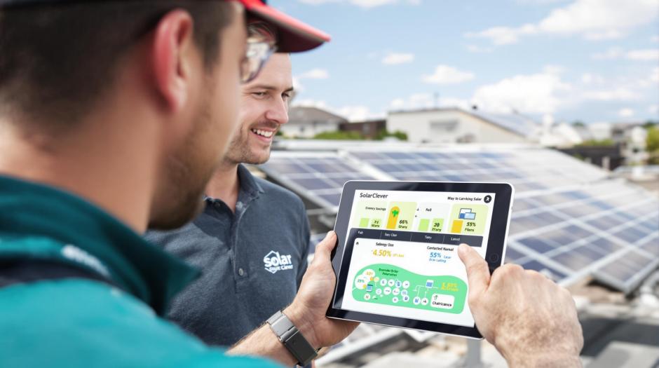 Solaranlage-kaufen Ein SolarClever Mitarbeiter zeigt einem Kunden die 3D Planung auf einem Tablet