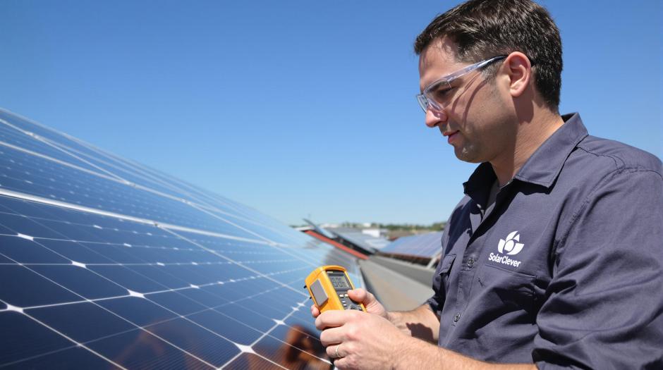 Solaranlage-kaufen Ein Techniker ueberprueft die Leistung einer Solaranlage mit einem Messgeraet